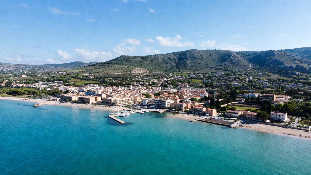 Vue d’Olbia en Sardaigne avec plages de sable clair, mer turquoise et port, illustrant les activités et paysages naturels.