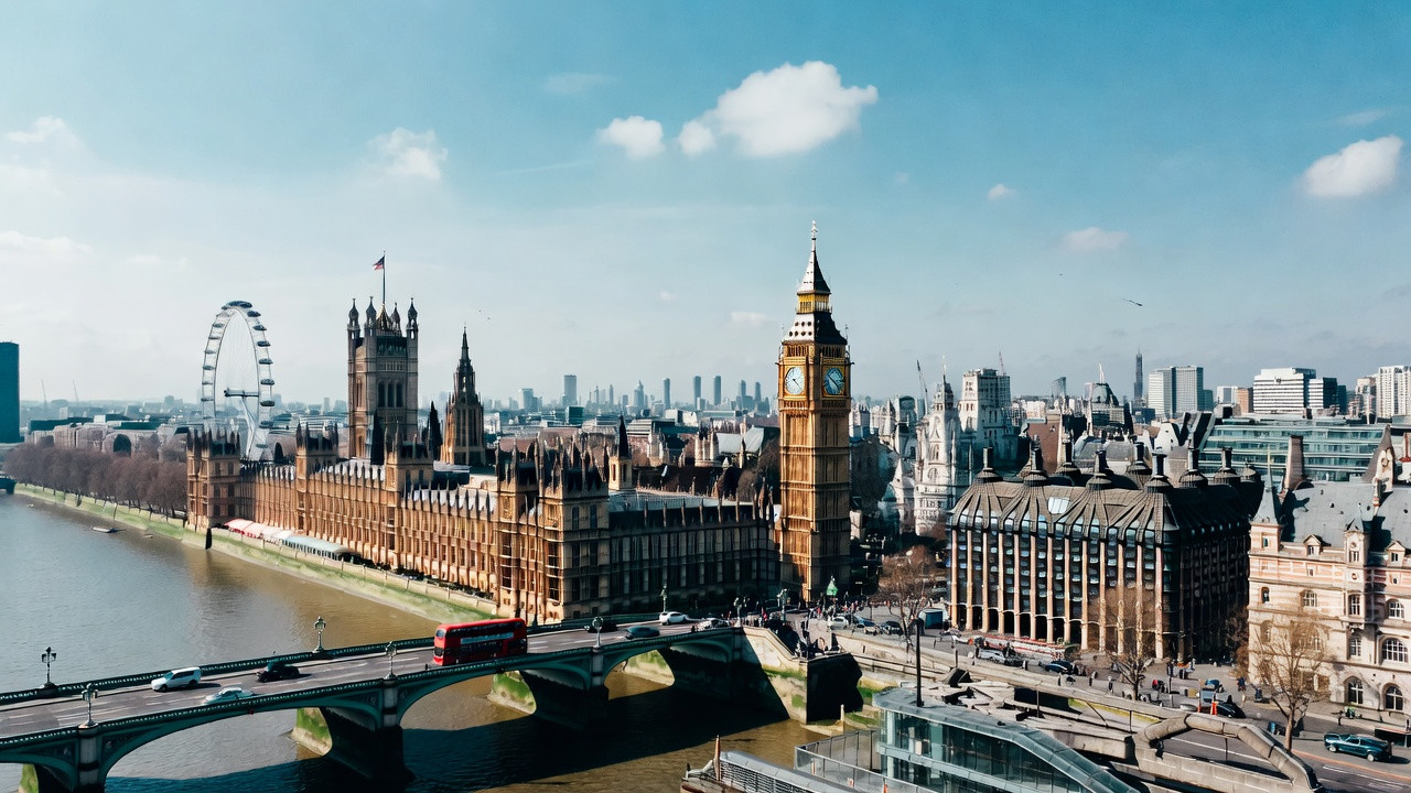 Vue de Londres avec Big Ben, le London Eye, la Tamise et un bus rouge à impériale, illustrant un guide pour visiter Londres en trois jours.