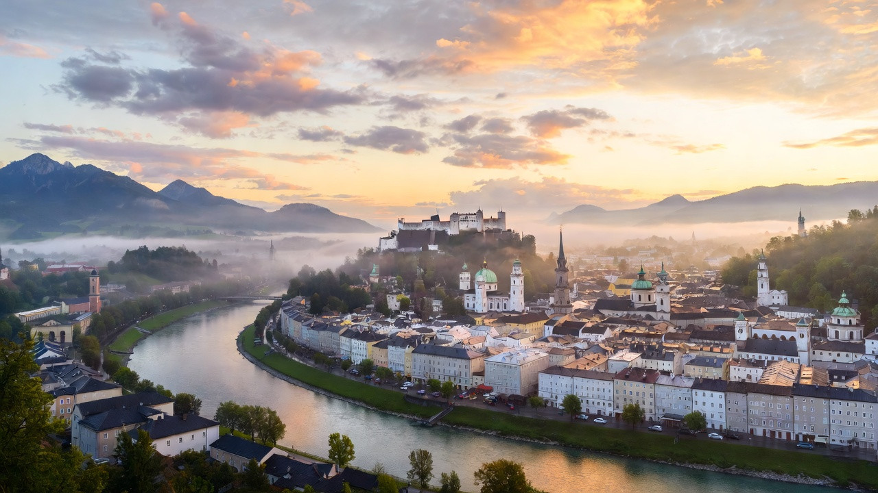 Vue panoramique de Salzbourg avec la forteresse de Hohensalzburg surplombant la vieille ville et la rivière Salzach au lever du soleil.